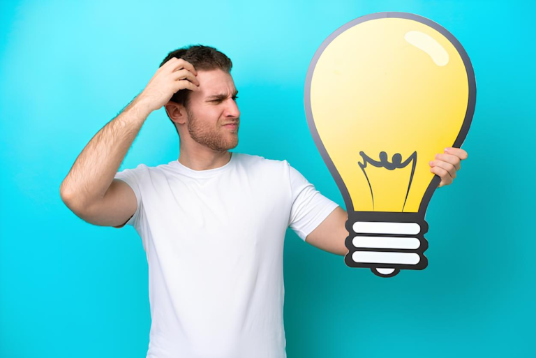young caucasian man isolated blue background holding bulb icon having